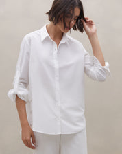Camisa feminina off-white manga longa em algodão vista 3/4 com gola clássica e caimento solto - Coleção Alto Verão 2026