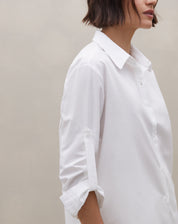 Look frontal completo: camisa branca longa off-white combinada com calça reta off-white em conjunto monocromático - vista frontal