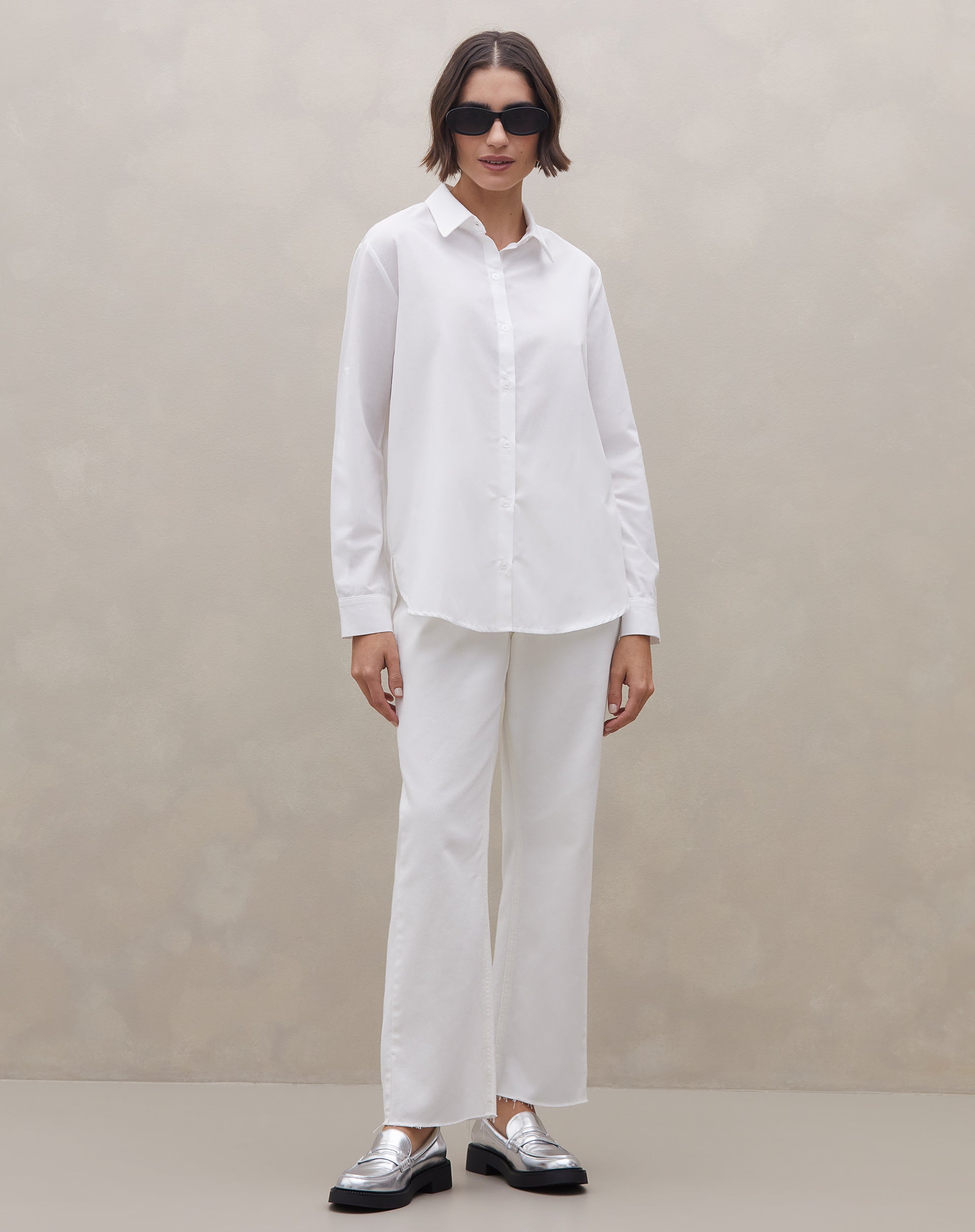 Detalhe da camisa off-white com mangas dobradas e passador, punho simples e barra arredondada - tecido liso 55% algodão