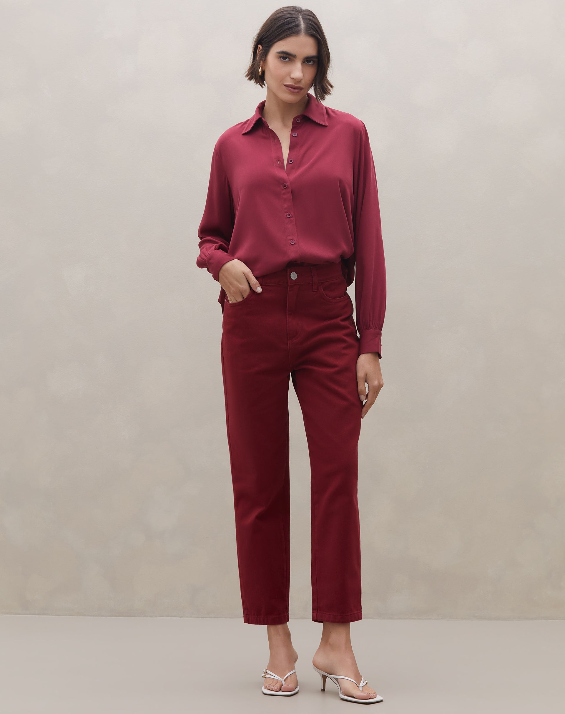 Vista traseira da camisa viscose vinho com prega central nas costas e barra arredondada