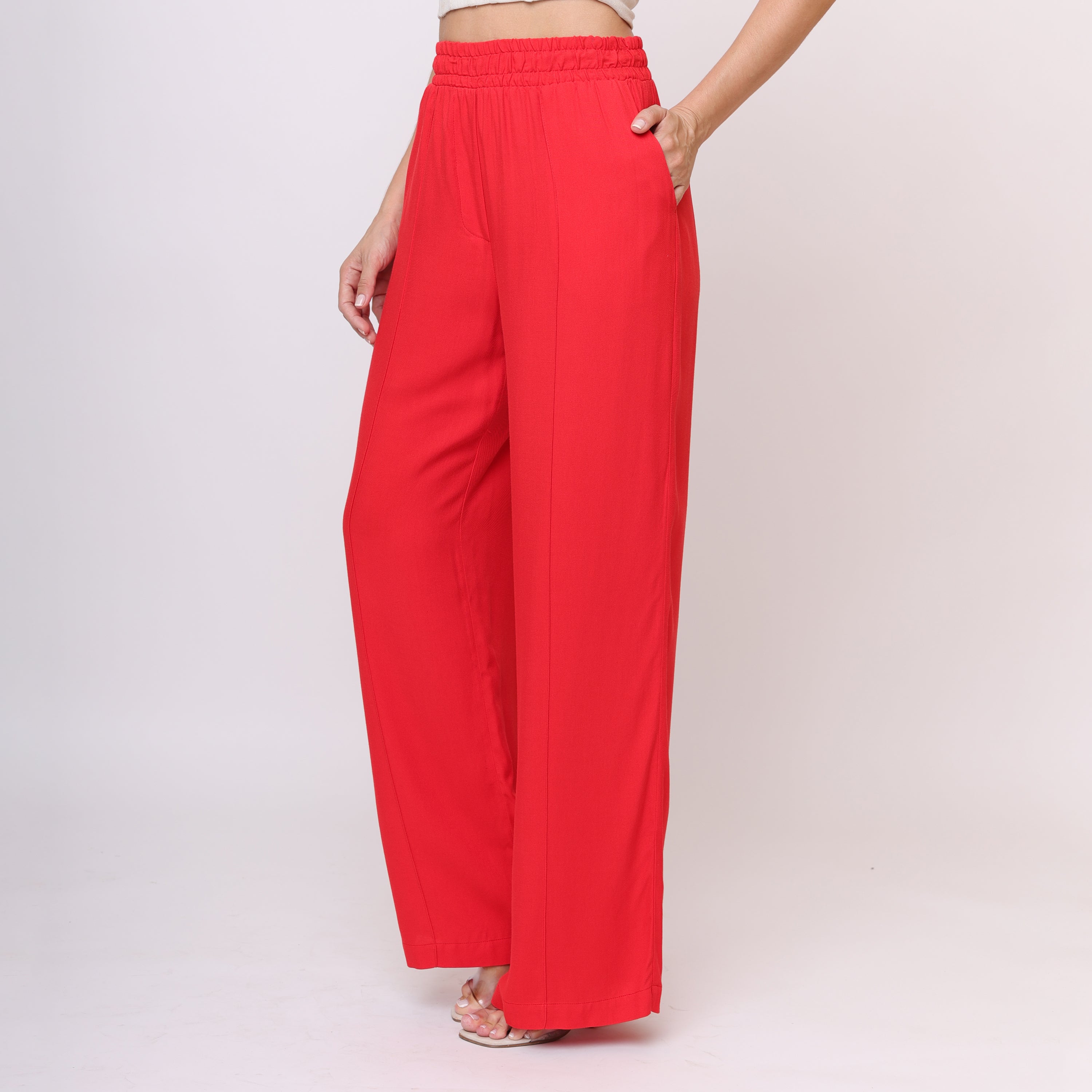 Vista traseira da calça pantalona vermelha mostrando cós alto elástico e caimento fluido na perna, acabamento liso